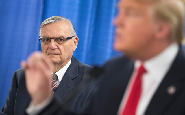 Former Maricopa County Sheriff Joe Arpaio looks on as then-presidential candidate Donald Trump speaks to reporters.