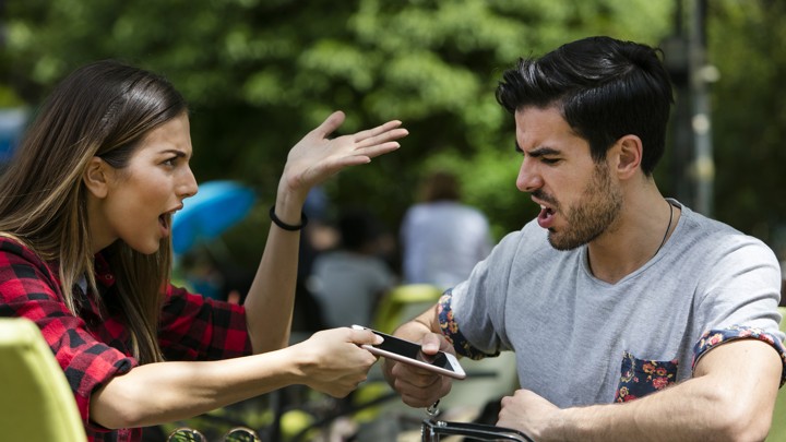 A couple argues while fighting over a smartphone.
