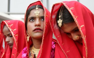 A young Pakistani bride in a sari looks up at the sky during a mass wedding ceremony in Karachi.