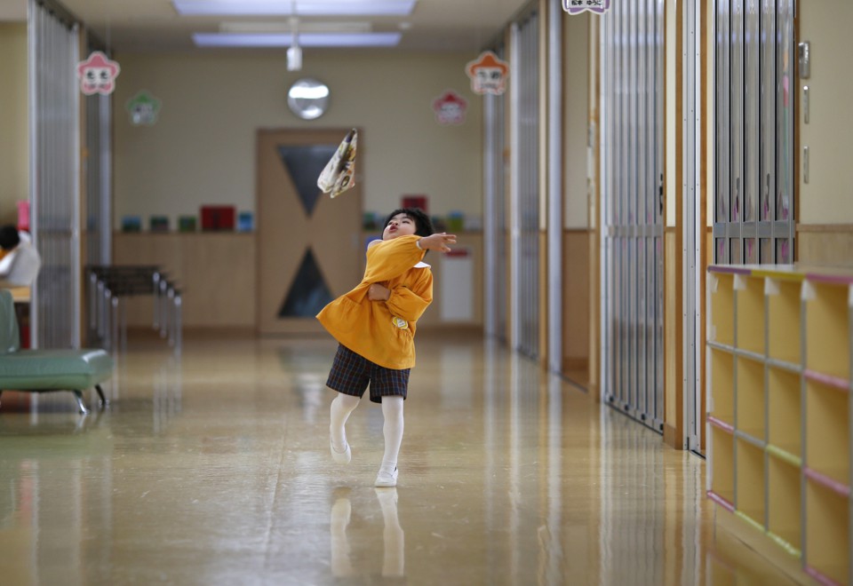 A boy plays in the hallway of a school in Japan