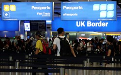 Travelers line up at the U.K. border control at Heathrow Airport in London on July 30, 2017. 