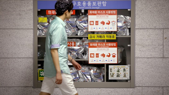 A young man walks in front of a relief goods storage inside of a subway in Seoul, South Korea.