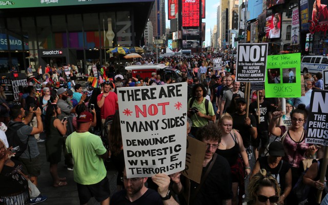 A protester holds up a sign denouncing white terrorism.