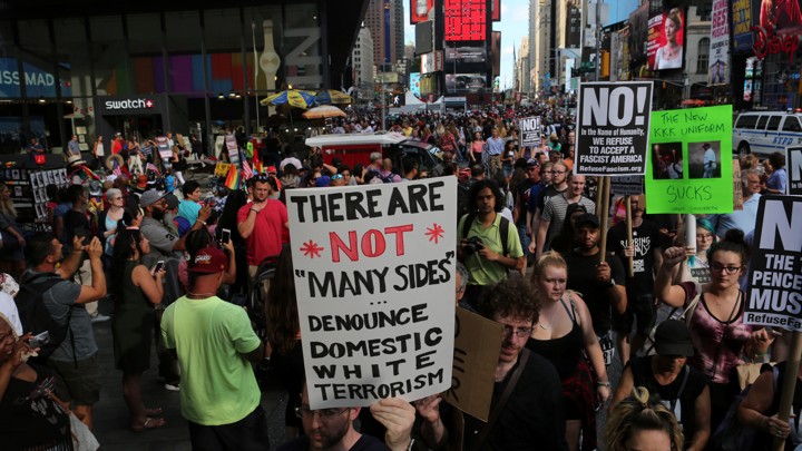 A protester holds up a sign denouncing white terrorism.