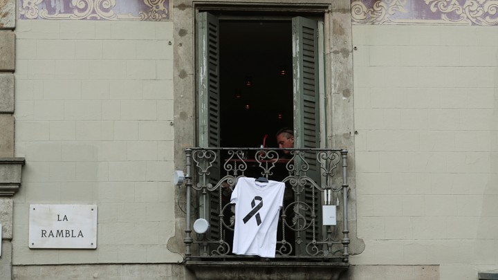 A T-shirt with a black ribbon hangs from a balcony