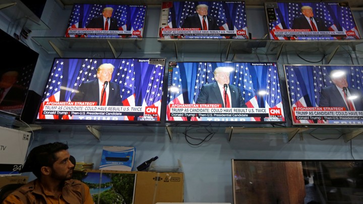 An Afghan man watches TV coverage of President Trump's address.