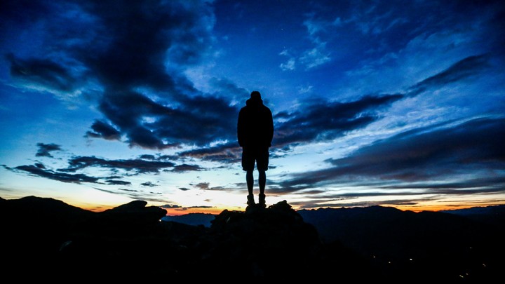 A man stands atop a cliff.