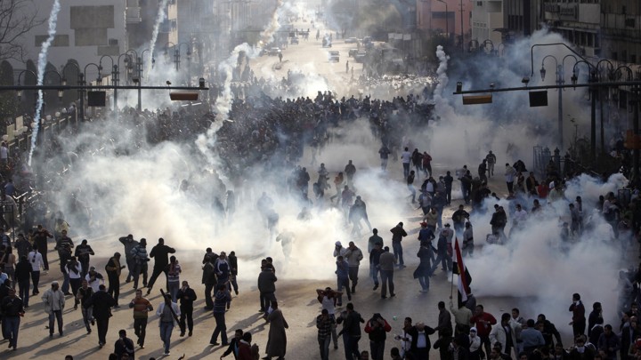 Protesters flee from tear gas fire during clashes in Cairo.