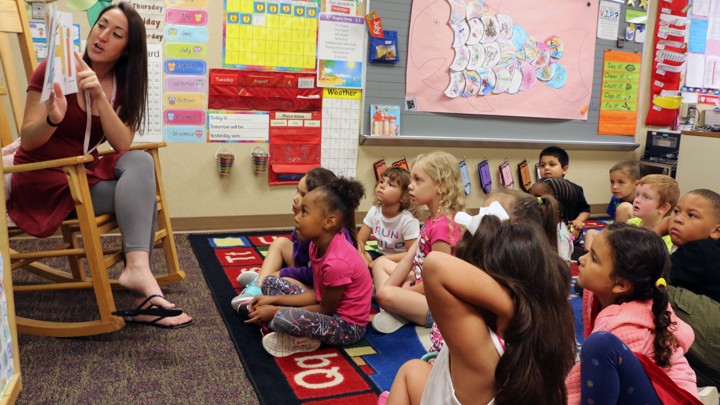 A kindergarten teacher reads to students.