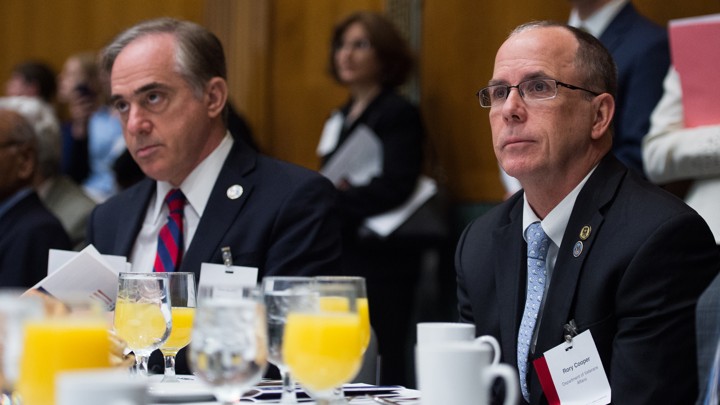 Veterans Affairs Secretary David Shulkin and award winner Rory Cooper sit at a table at the 2017 Sammies finalist-announcement breakfast.