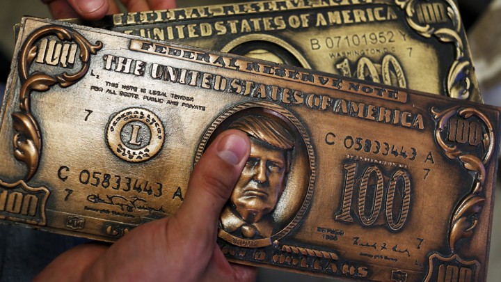 A mock, metallic money-printing plate with President Trump's face on it