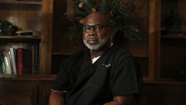 Willie Parker wears scrubs in an office.