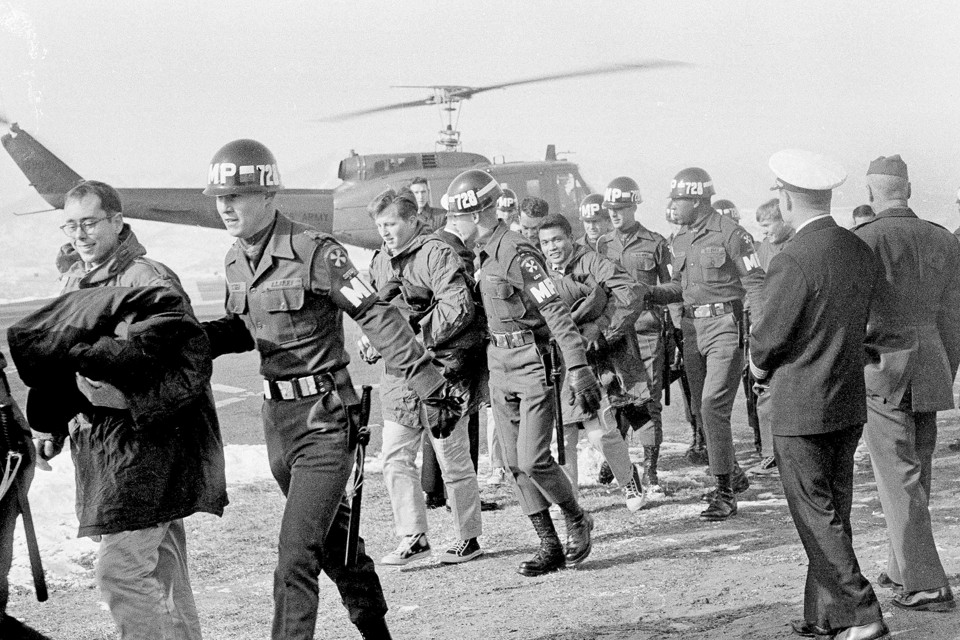Released crewmen of the USS Pueblo are escorted by MPs off a helicopter.
