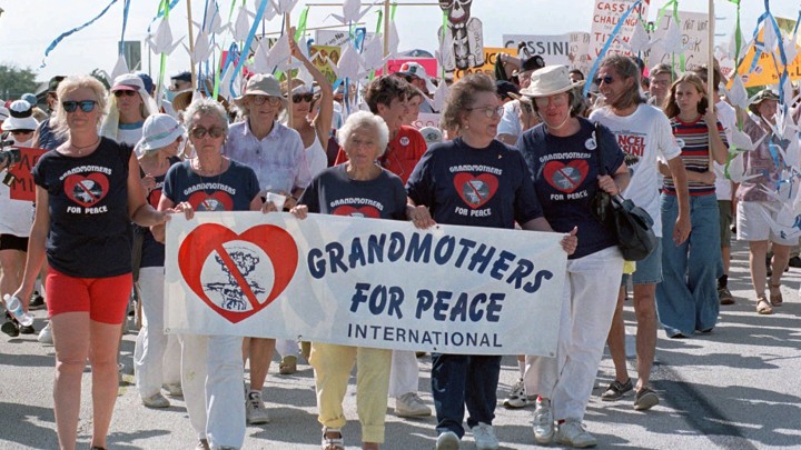 Protesters hold a sign that says "Grandmothers for Peace International"