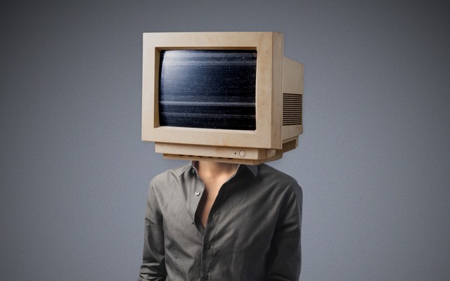 A person whose head has been replaced with a bulky desktop monitor