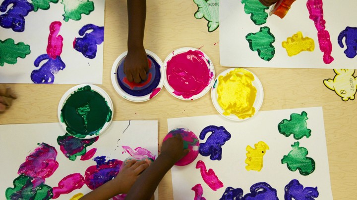 Children use stamps dipped in paint to make art.