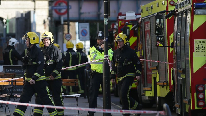Members of the emergency services work outside Parsons Green underground tube station