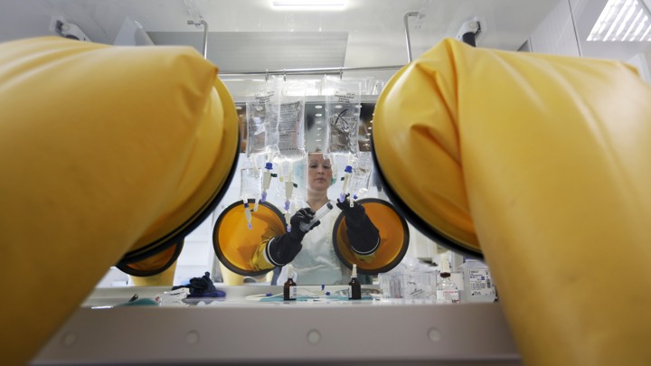 A dispensing chemist prepares drugs for a chemotherapy treatment in a sterile room.