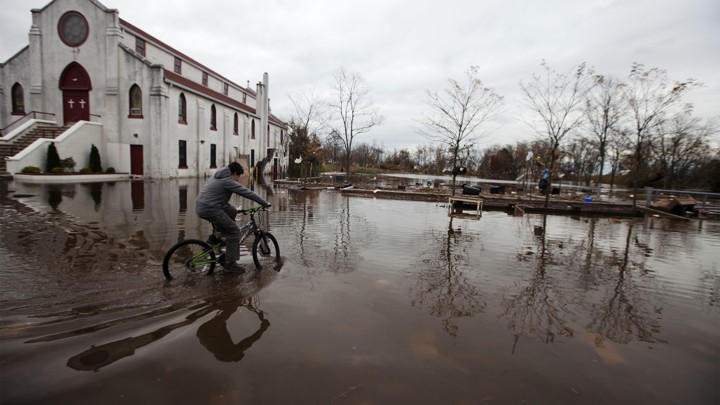 A boy rides his bicycle through floodwaters in the New Dorp Beach neighborhood of Staten Island, New York, on November 1, 2012.