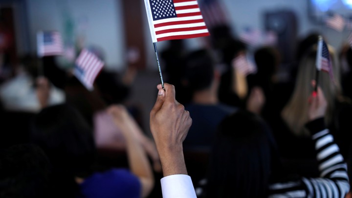 A new citizen waves an American flag during a naturalization ceremony.