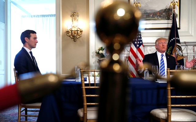 Jared Kushner sits at a table with Donald Trump.