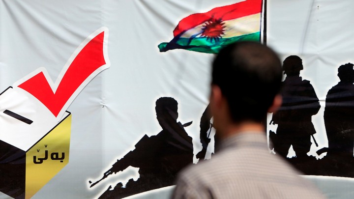 A man looks at a banner supporting the referendum for independence of Kurdistan