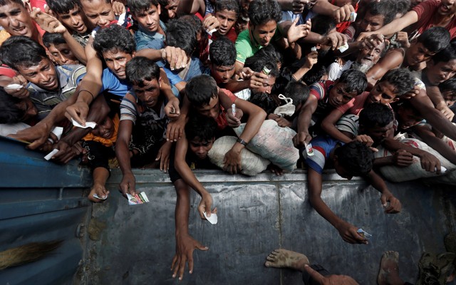 Rohingya refugees wait to receive aid in Cox's Bazar.