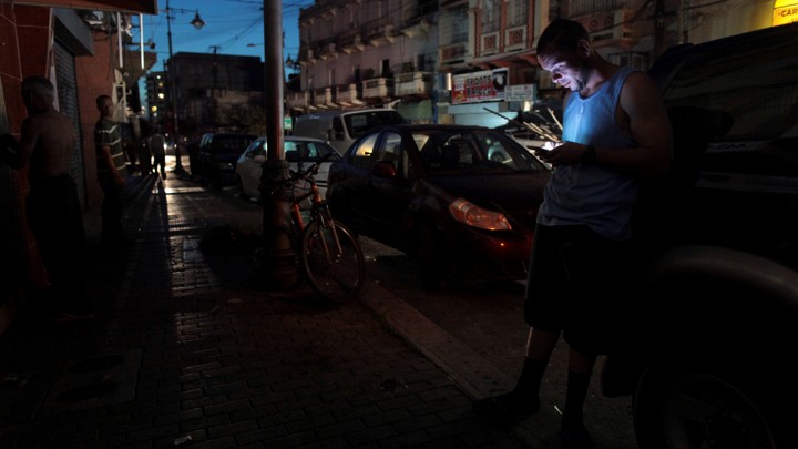A man uses his phone during a blackout in San Juan, Puerto Rico.