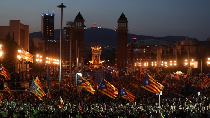 People wave Catalan separatist flags at a rally