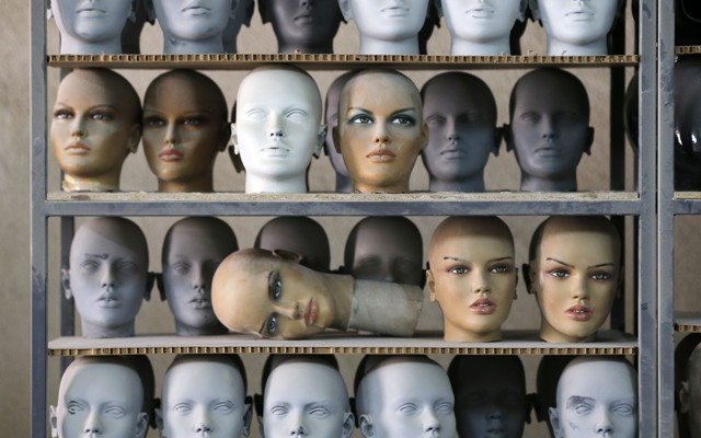 Mannequin heads sitting on a shelf in a factory 