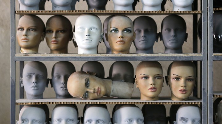 Mannequin heads sitting on a shelf in a factory