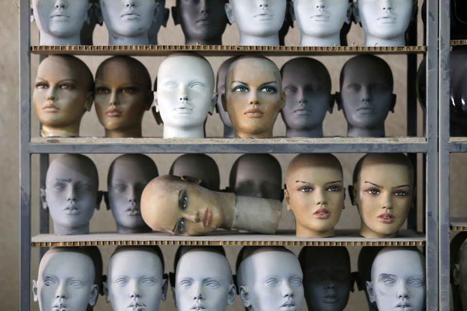 Mannequin heads sitting on a shelf in a factory 