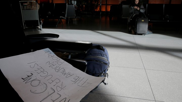 A sign welcoming refugees lies on a bench