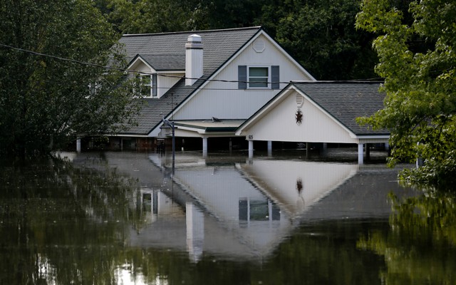 A two-story house halfway underwater 