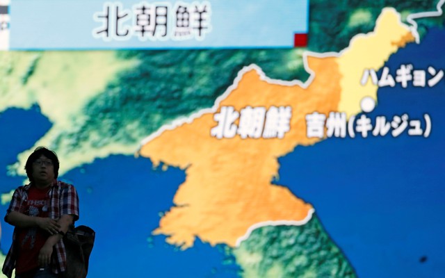 People walk past a street monitor showing a news report about North Korea's nuclear test in Tokyo, Japan.