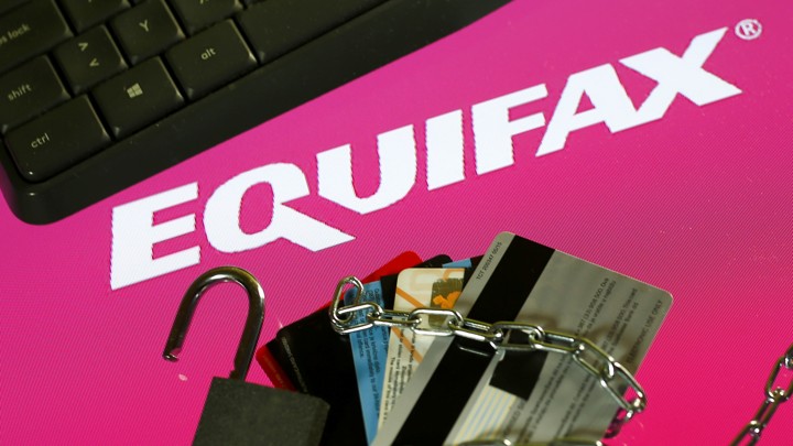 A keyboard, credit cards, chain, and padlock next to the Equifax logo