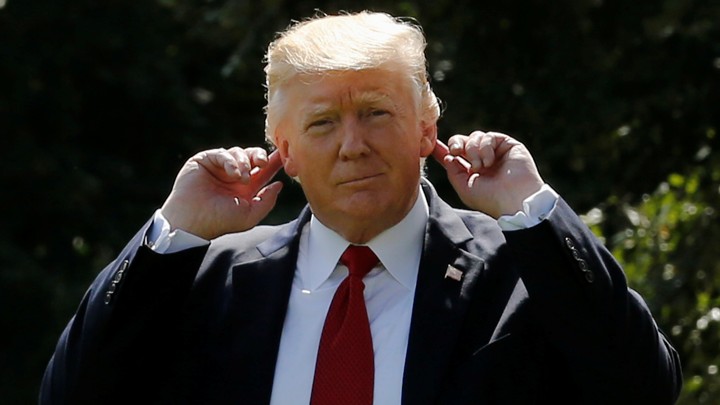 Donald Trump motions to his ears.