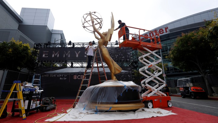 Workers install a large Emmy statue ahead of the 2017 awards ceremony