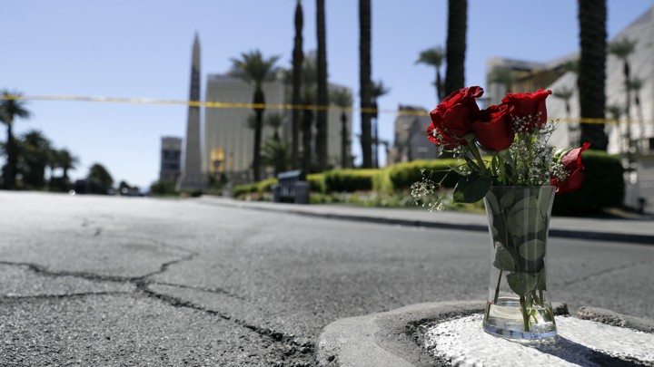 A vase of roses on a sidewalk