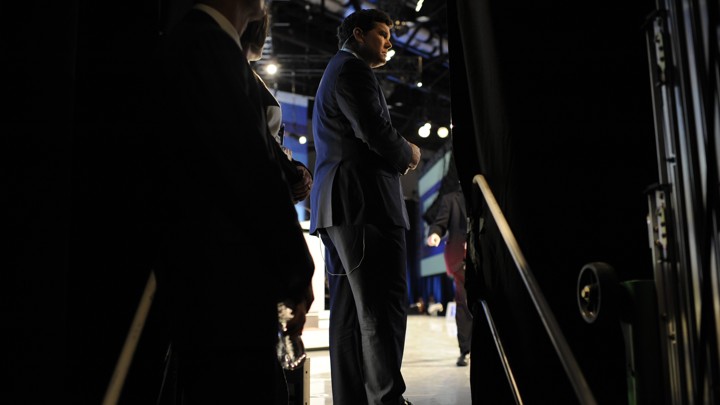 Fox News Anchor Bret Baier framed by two dark curtains on a stage