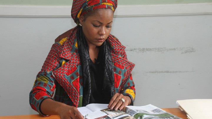 MacDella Cooper reads a magazine at her desk.