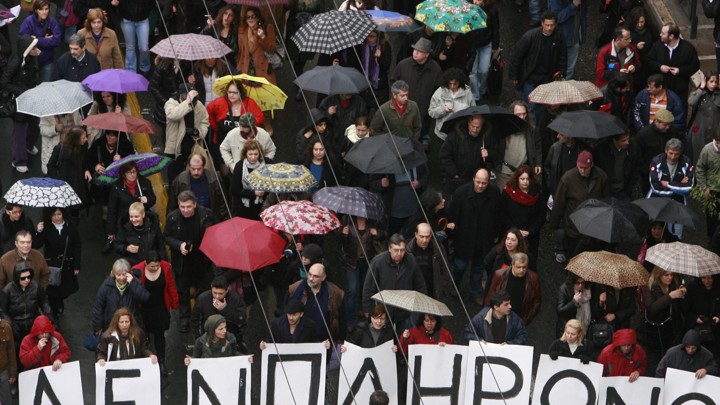 Protesters march under umbrellas during an anti-government rally