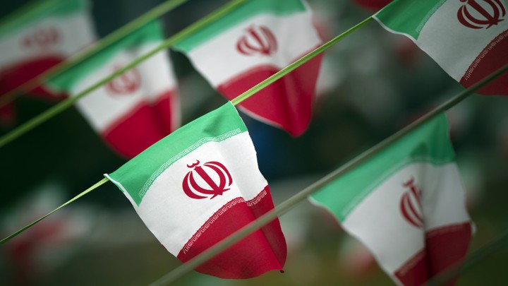Iran's national flags are seen fluttering on a string in a square.