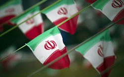 Iran's national flags are seen fluttering on a string in a square.