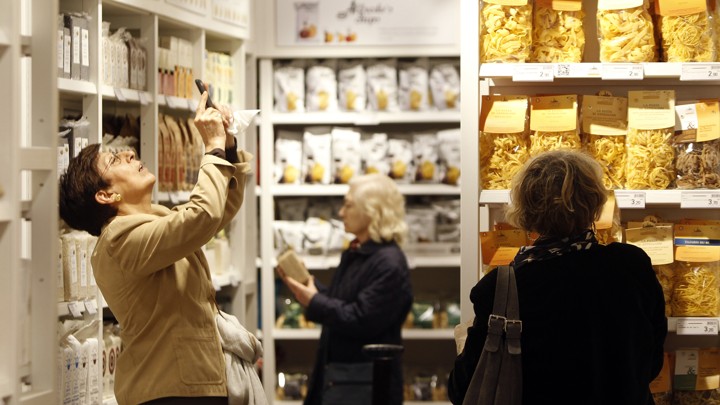 Shoppers select products and take pictures on their smartphones at an Eataly store.