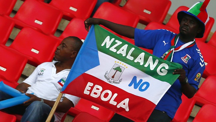 A fan holds an Equatorial Guinea flag with an anti-Ebola message at the African Cup of Nations.