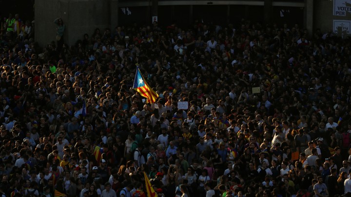 A Catalan separatist flag flutters in the middle of a crowd.