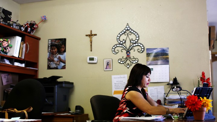 A woman sits at a desk in an office