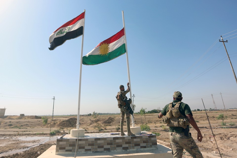 An Iraqi soldier takes down a Kurdish flag in Kirkuk