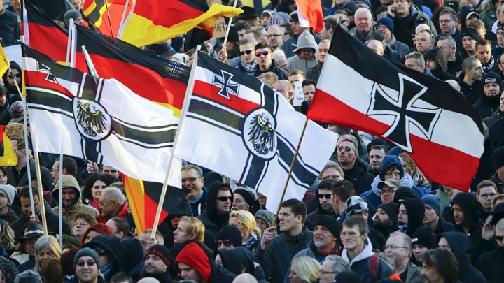 Supporters of the anti-immigration right-wing movement Patriotic Europeans Against the Islamization of the West carry various versions of the Imperial War Flag during a protest.